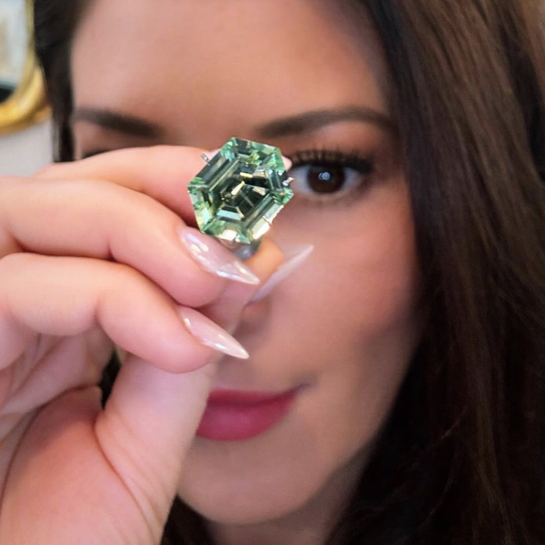 Elizabeth Wahler examining exceptional mint green tourmaline, showcasing Elyzian's gemstone expertise