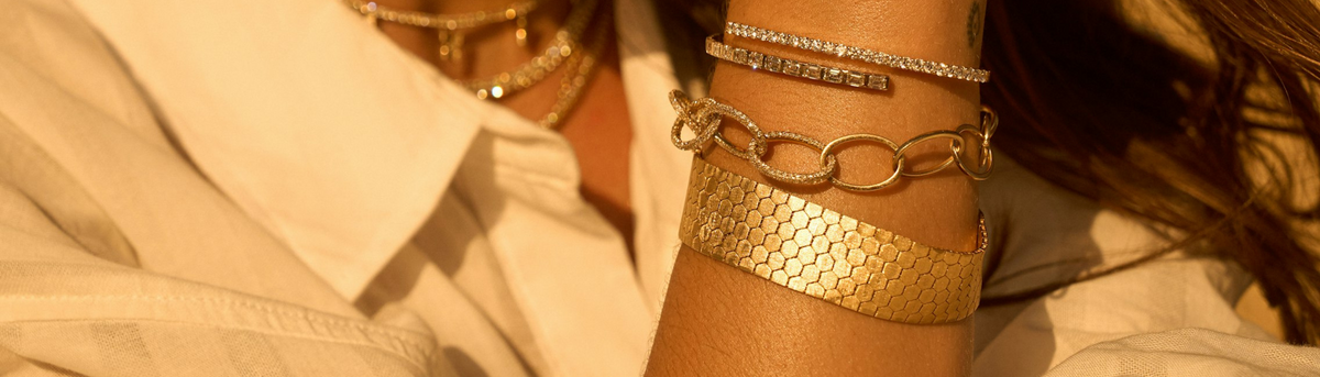 Stacked gold and diamond bracelets on the wrist