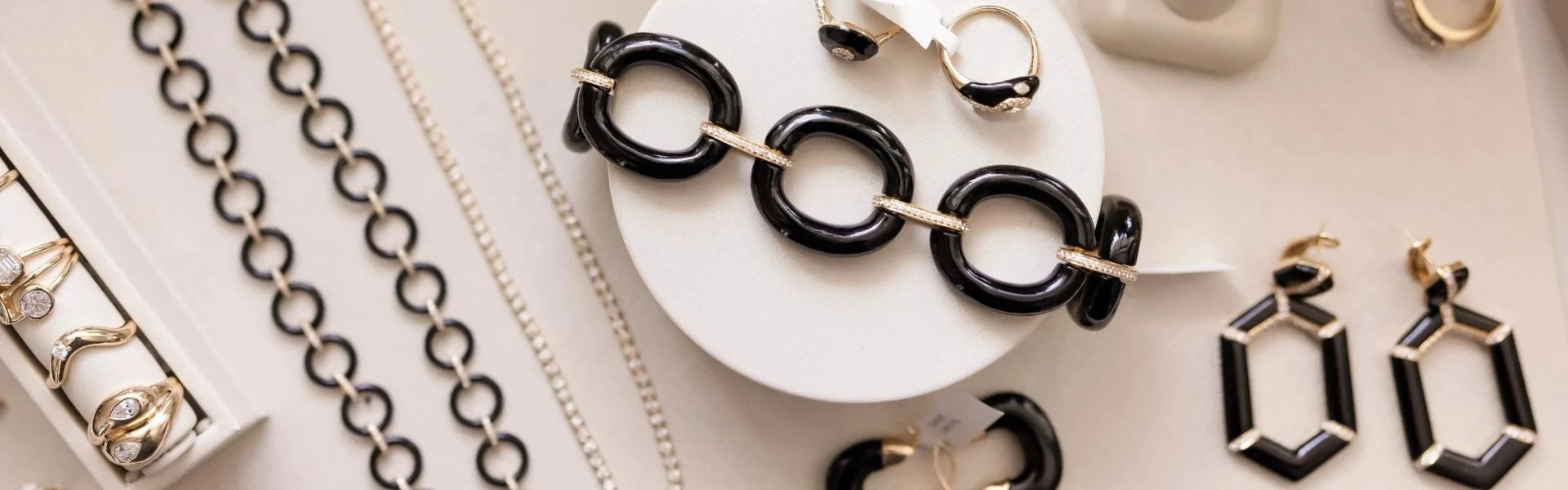 Elyzian black onyx bracelet earrings and chains from the onyx edit collection, luxury fine jewelry flatlay styling