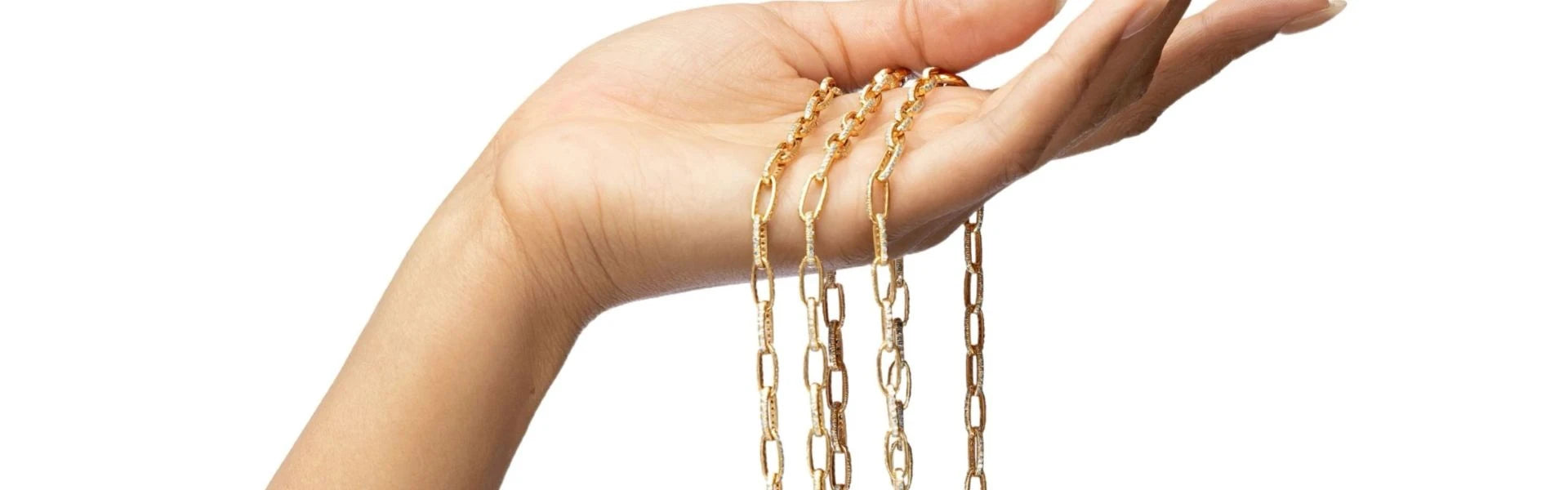 Elyzian gold chain necklaces with paperclip links draping from hand, luxury layering jewelry collection
