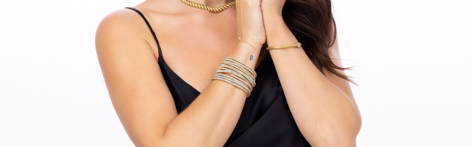 Diamond tennis bracelets stacked on wrist with gold jewelry, Elyzian Tennis Shop collection