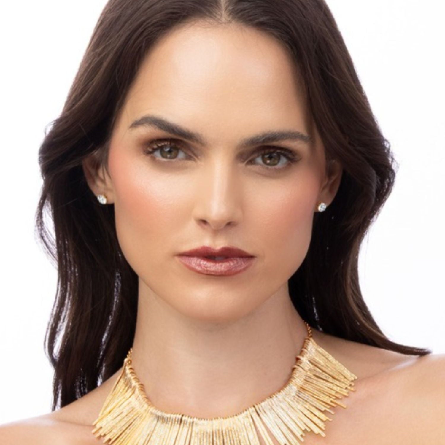 Woman wearing a gold fringe necklace on a white background