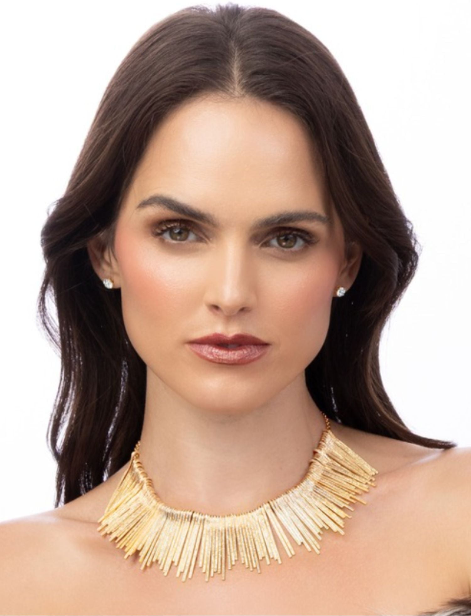 Woman wearing a gold fringe necklace on a white background