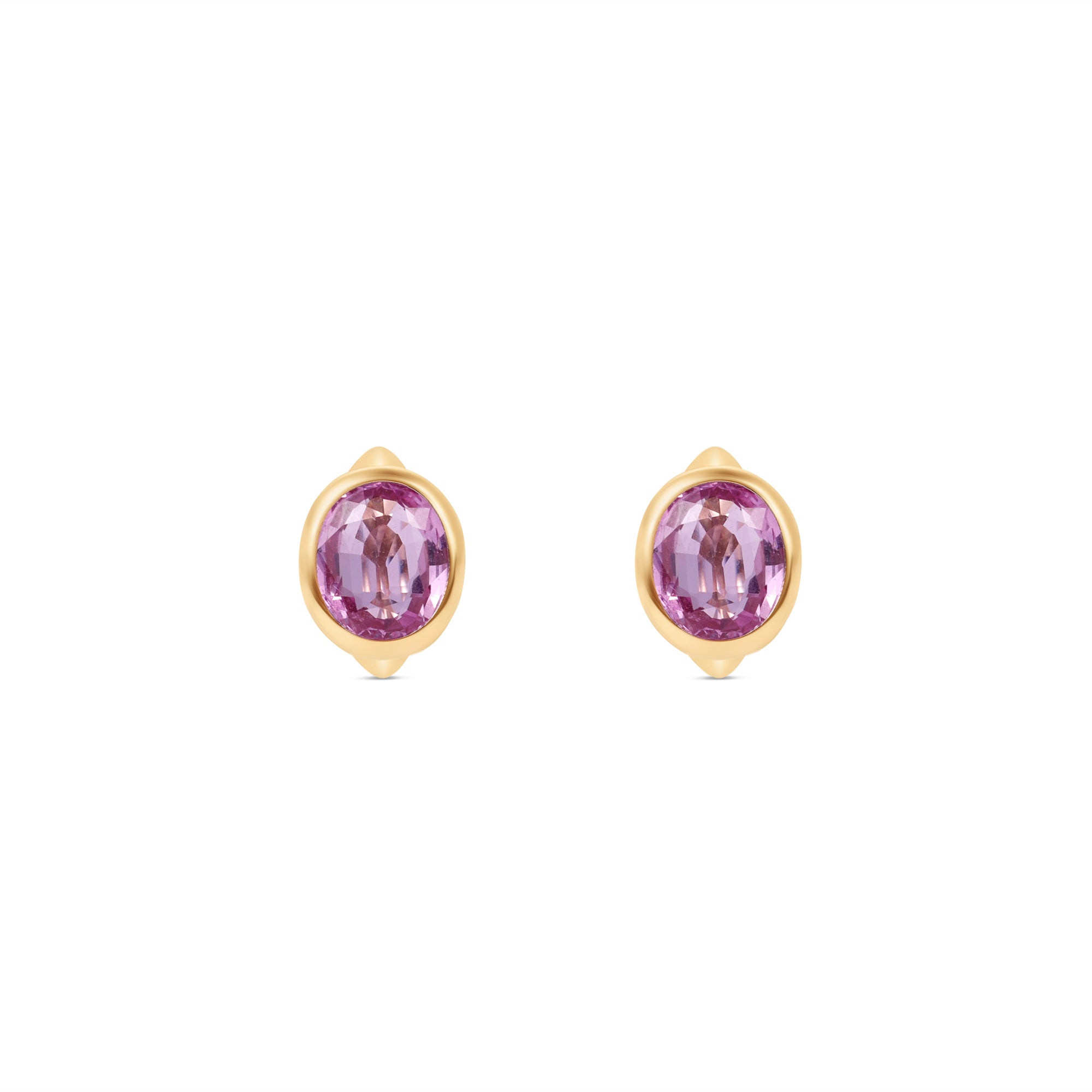 Enchanting pink sapphire huggie earrings crafted in 14K yellow gold, featuring vibrant oval-cut pink sapphires for a perfect blend of charm and sophistication, suitable for any occasion. Front view, close up. 