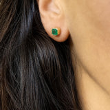 Asscher-cut Colombian emerald stud earring in 18K yellow gold, close view of the bezel setting