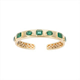 Exquisite 14K yellow gold bangle featuring seven bezel-set emeralds in mixed shapes totaling 10 carats, creating a bold yet refined statement of elegance and color.