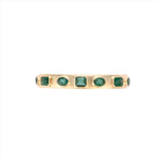 Exquisite 14K yellow gold bangle featuring seven bezel-set emeralds in mixed shapes totaling 10 carats, creating a bold yet refined statement of elegance and color.