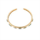 Exquisite 14K yellow gold bangle featuring seven bezel-set emeralds in mixed shapes totaling 10 carats, creating a bold yet refined statement of elegance and color.
