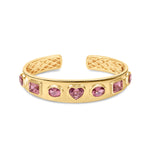 Exquisite 14K yellow gold bangle featuring seven mixed-shape pink tourmalines, including oval, cushion, and heart shapes, blending sophistication with playful charm for a luxurious statement piece. Font and detail of inside. 