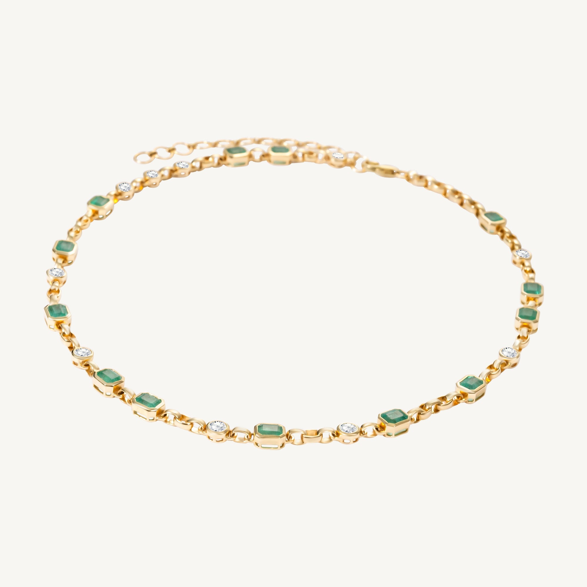 Handmade 14K yellow gold adjustable rolo chain necklace featuring 13 bezel-set emerald cut Zambian emeralds (6.12ct) and 10 bezel-set solitaire diamonds (1.74ct), offering refined elegance with a bold touch.