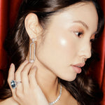 Exquisite 14K white gold cocktail ring featuring a vibrant aquamarine centerpiece framed by sparkling diamond accents, capturing attention with its dazzling design. On model with diamonds, pearls and cocktail ring.