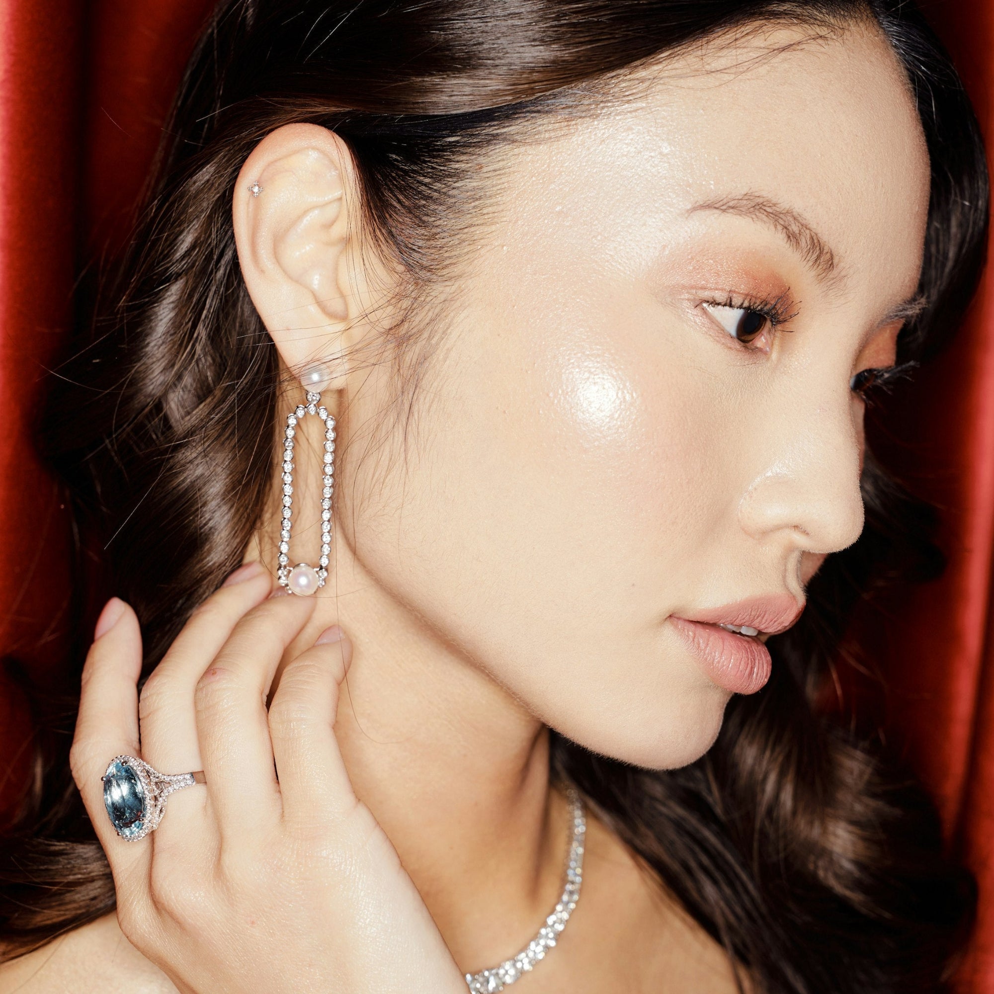Exquisite 14K white gold cocktail ring featuring a vibrant aquamarine centerpiece framed by sparkling diamond accents, capturing attention with its dazzling design. On model with diamonds, pearls and cocktail ring.