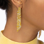 Statement 14K yellow gold earrings featuring hand-selected yellow sapphires and brilliant diamonds, radiating warmth and elegance inspired by the golden glow of sunlight. On model. 