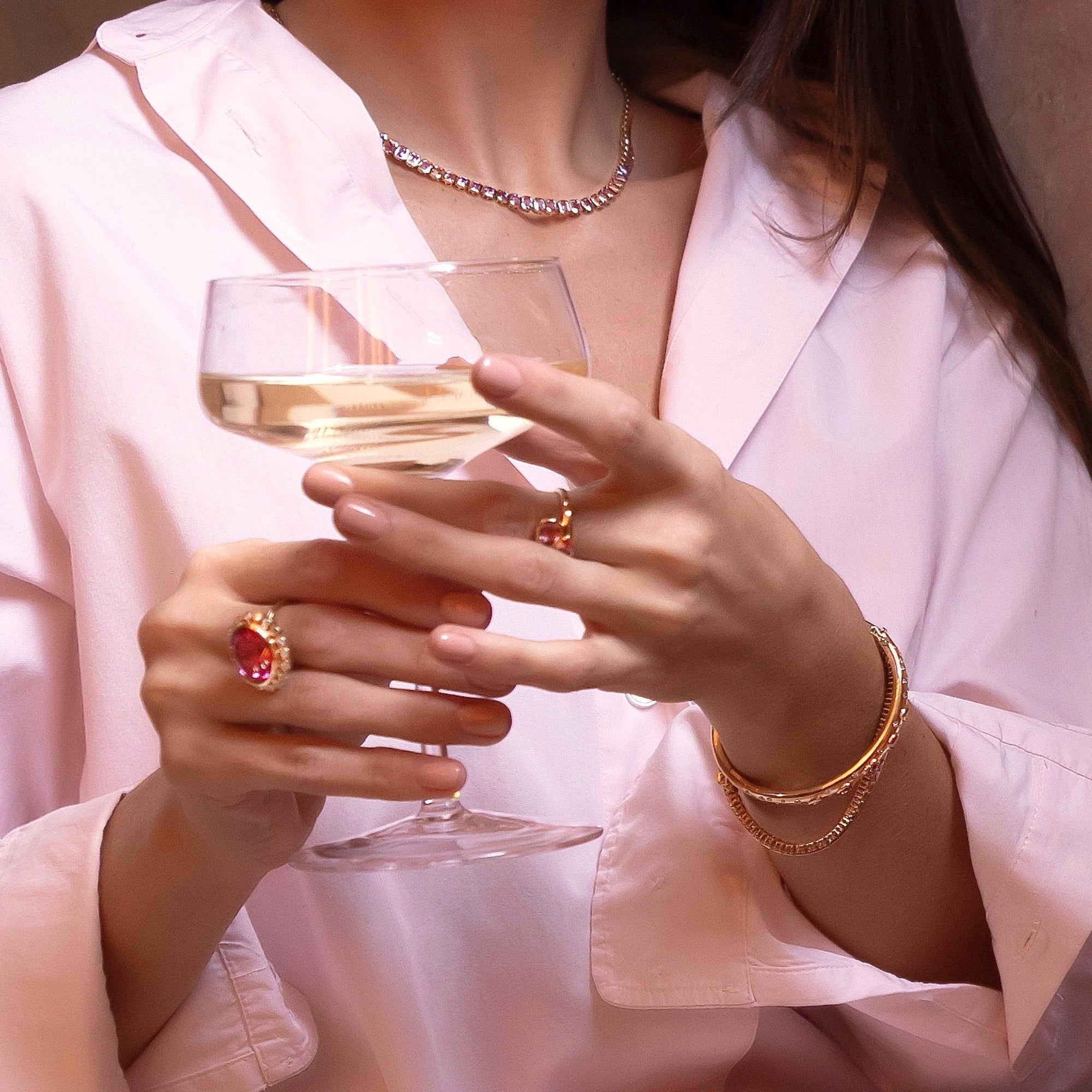 Luxurious 14K yellow gold tennis necklace featuring 10.14ct of bezel-set emerald cut pink sapphires, 16 inches in length and weighing 25.74g—a refined and radiant statement piece.