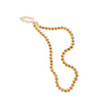 Elegant 14K gold tennis necklace featuring vibrant bezel-set and trillion-cut goldenrod orange sapphires, offering a modern twist on a timeless design with luxurious flair. Details in movement