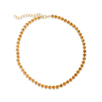 Elegant 14K gold tennis necklace featuring vibrant bezel-set and trillion-cut goldenrod orange sapphires, offering a modern twist on a timeless design with luxurious flair.