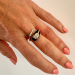 Captivating serpent ring crafted from 14K yellow gold and black enamel, featuring 0.35ct of G-H VS diamonds—an exotic and bold statement piece with luxurious edge. On finger.
