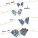 Extra-large 18K yellow gold articulated butterfly necklace featuring luminous blue labradorite wings that shift with light, accented by sparkling diamonds for a bold and elegant statement piece. Close up of four sizes.