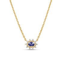 Exquisite anemone flower necklace featuring a stunning oval-cut blue sapphire at the center, surrounded by ten pear-shaped diamonds in a captivating floral design, crafted in elegant gold. Close up of front view. 