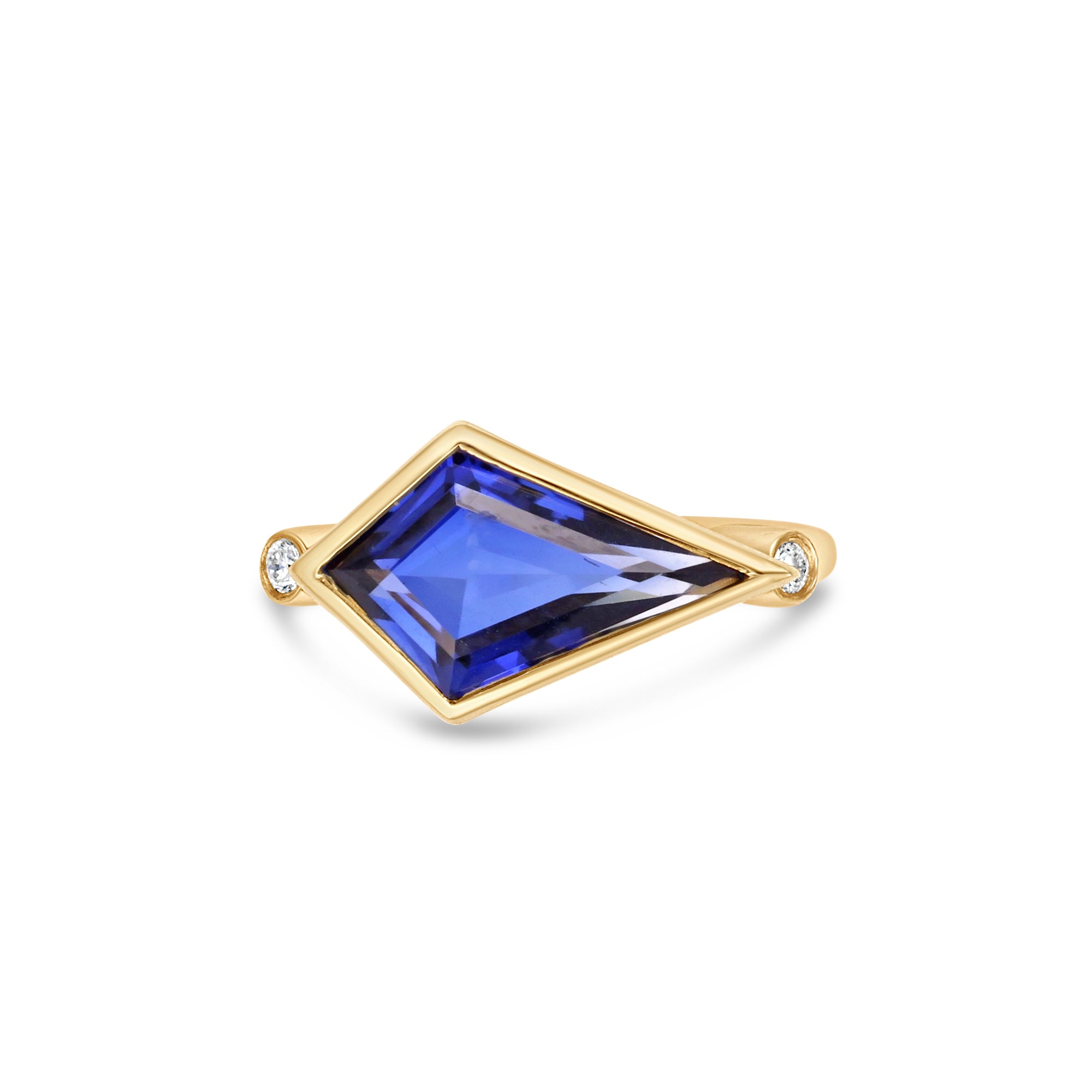 Elegant 18K yellow gold kite ring featuring a mesmerizing blue sapphire, accented by two bezel-set diamonds, merging bold geometry with timeless sophistication. Front view, close up of stone. 
