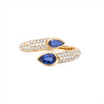 Elegant 14K yellow gold serpent-style bypass ring featuring two bezel-set pear-cut blue sapphires (0.735ct) and 0.482ct of G-H VS pavé diamonds, offering a bold and refined silhouette.