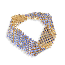 Masterfully crafted 14K yellow gold flexible woven cuff bracelet featuring vibrant cornflower blue sapphires, offering a radiant and timeless statement of Italian elegance. Shown clasped and flexible. 