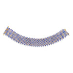Masterfully crafted 14K yellow gold flexible woven cuff bracelet featuring vibrant cornflower blue sapphires, offering a radiant and timeless statement of Italian elegance. Flat lay.