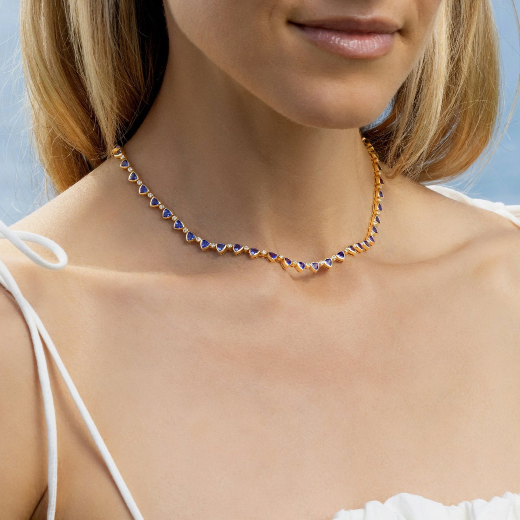 Elegant 14K yellow gold necklace featuring 11.19ct of vivid blue tanzanite and 0.98ct of round diamonds in bezel settings, with a total weight of 21.17g and a 44cm length—sophisticated and vibrant.