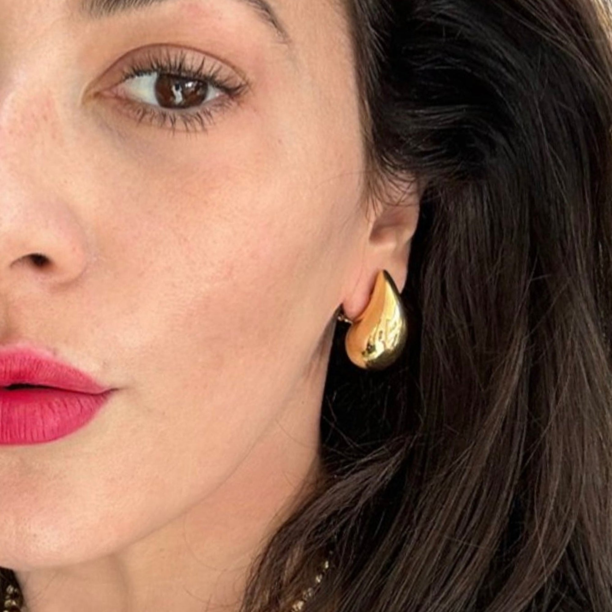 Striking 14K yellow gold teardrop earrings with a bold, oversized silhouette, crafted in semi-hollow gold for a lightweight yet statement-making design. On model in left ear. 