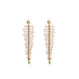 One-of-a-kind 14K yellow gold feather earrings featuring clear rock quartz, emeralds, and sparkling diamonds, designed for versatility—wear them as statement dangle earrings or transform the detachable feathers into a unique bracelet complemented by emerald stud earrings. Front close up as earrings. 