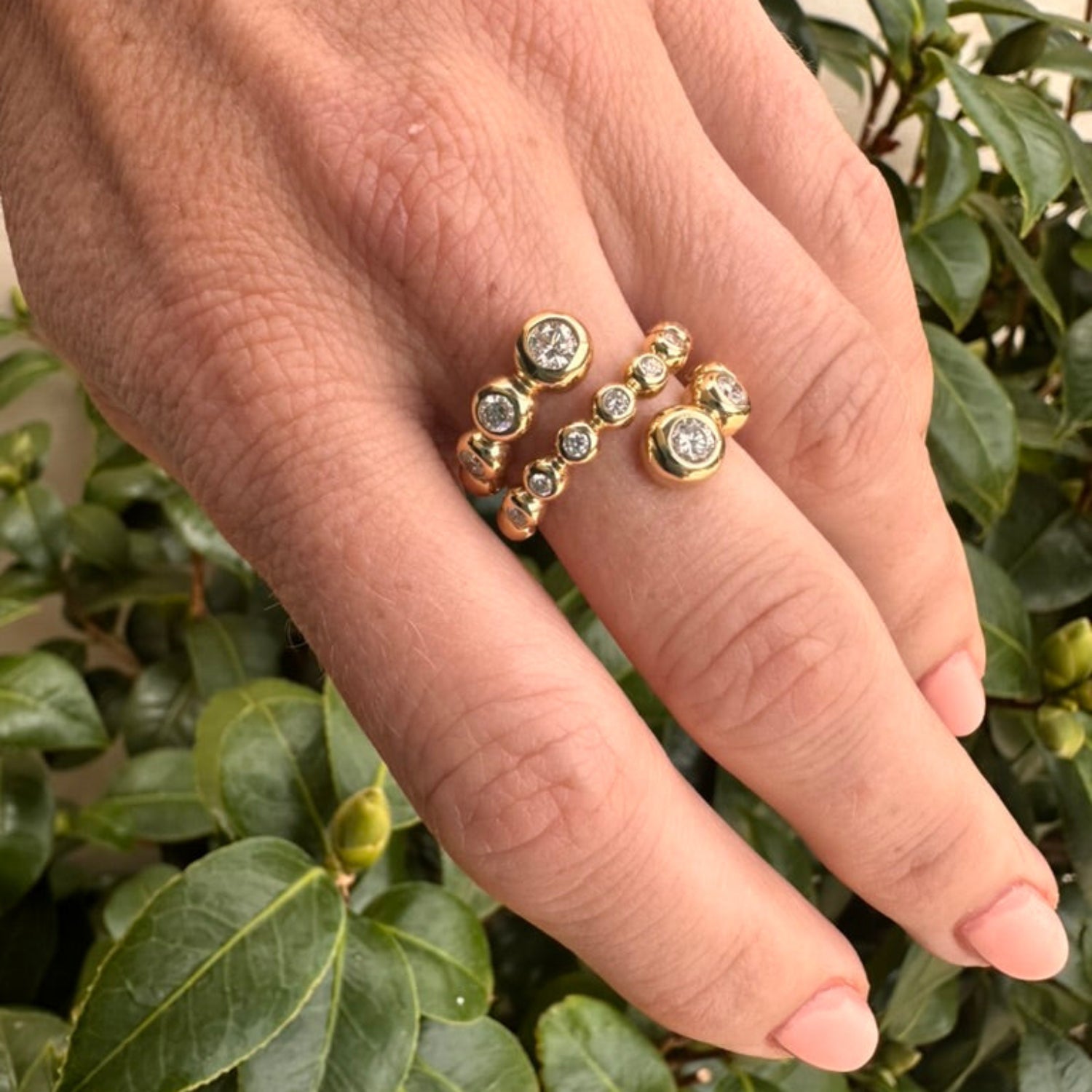 Stunning 14K yellow gold wrap ring featuring delicate bezel-set diamond bubbles, enhancing brilliance and creating a versatile, elegant accent for any occasion. On finger