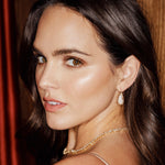 Classic diamond encrusted saddle hoop earrings crafted in 14K yellow gold, featuring a seamless array of sparkling diamonds for a timeless and elegant look. On model. 