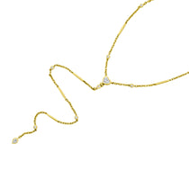 Versatile 14K yellow gold lariat necklace featuring round, pear, and heart-cut diamonds in an elegant, modern design. With a detachable feature that transforms into a matching bracelet set, this piece offers understated luxury and adaptable styling. Close up. 