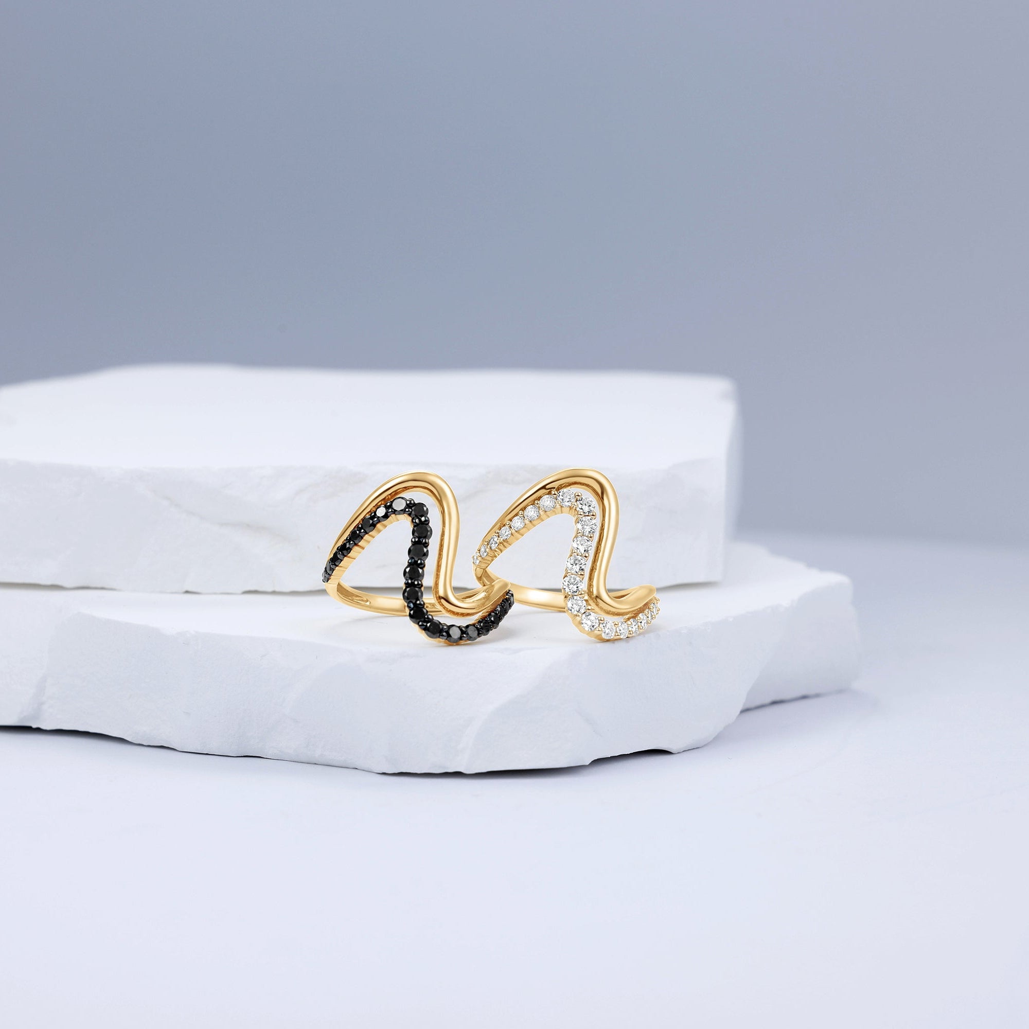 Striking 14K yellow gold wave ring featuring a bold double-wave design, accented with captivating black diamonds and sleek black rhodium details for modern elegance. Displayed with the white diamonds. 