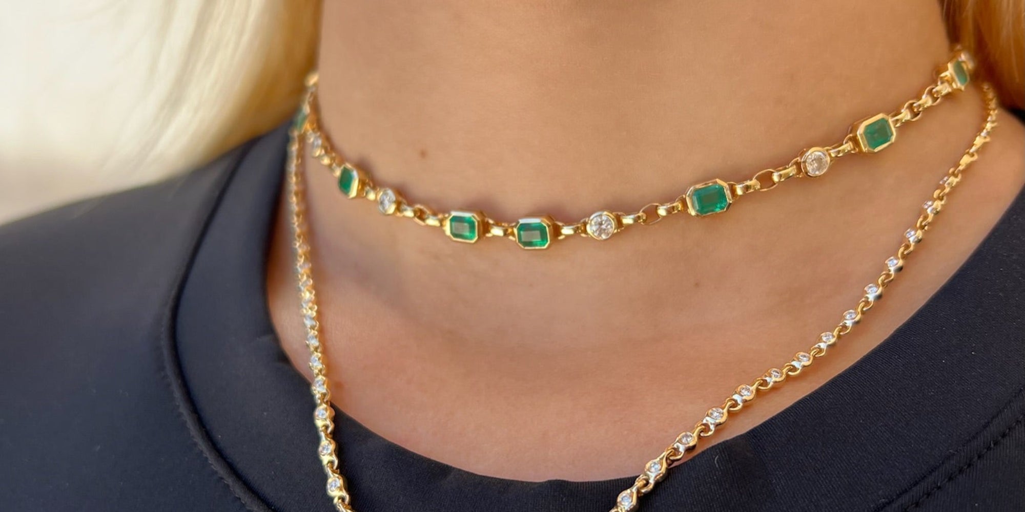 Elegant 14K yellow gold necklace featuring a 1ct bezel-set emerald solitaire pendant on a mini rolo chain with 0.58ct of diamond accents and an adjustable 16–18 inch length.