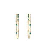 Captivating double hoop earrings featuring shimmering diamonds and vibrant emeralds in a double huggie design, accentuated by delicate dangling chains for a blend of classic sophistication and modern allure.Front view, close up.