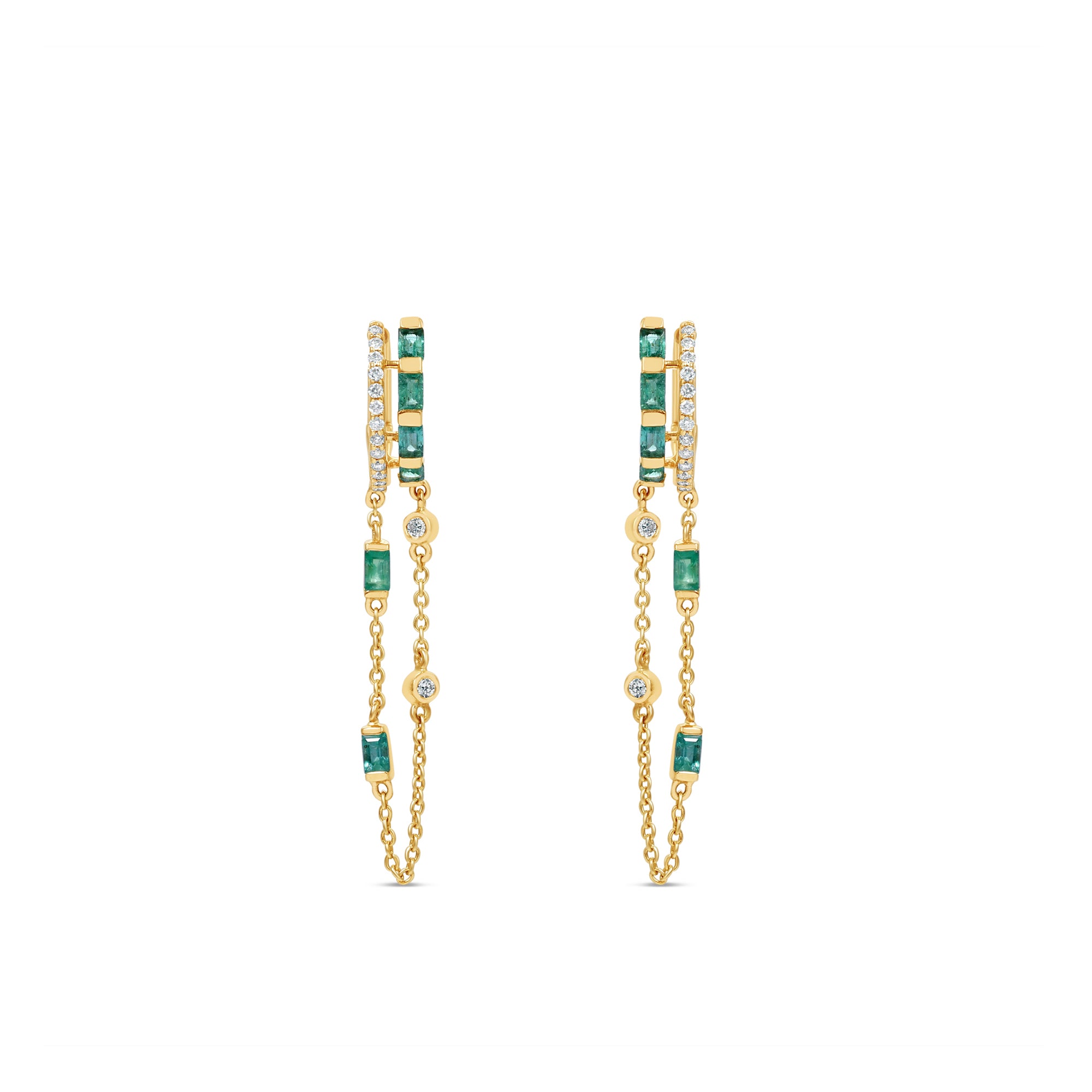 Captivating double hoop earrings featuring shimmering diamonds and vibrant emeralds in a double huggie design, accentuated by delicate dangling chains for a blend of classic sophistication and modern allure.Front view, close up.