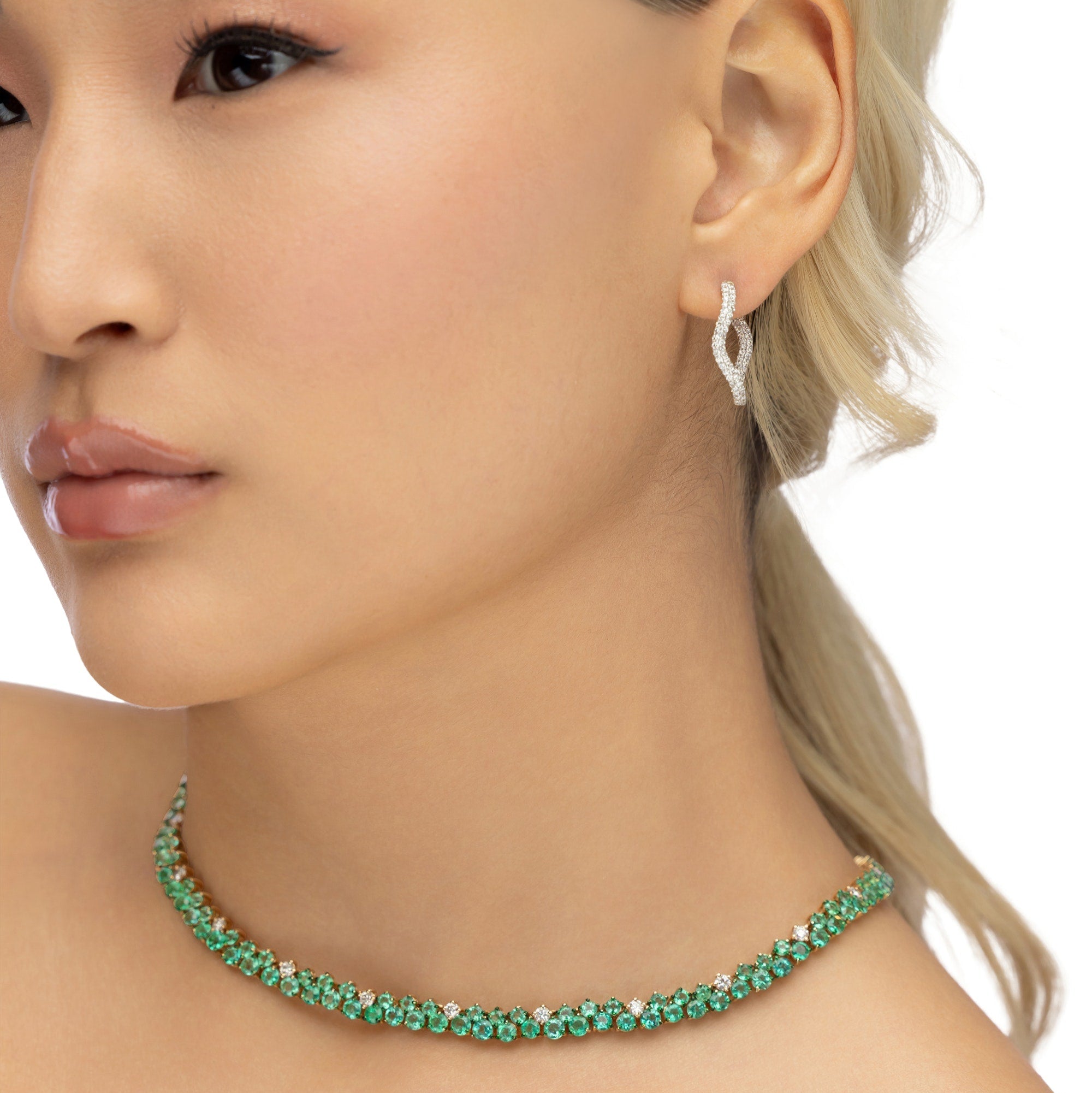 Mesmerizing dual tennis necklace crafted in 14K yellow gold, featuring vivid emeralds and sparkling diamond accents, offering a sophisticated and timeless design for elevating any ensemble.