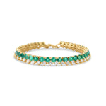 Timeless 14K yellow gold line bracelet featuring vibrant emeralds and radiant diamonds, offering a bold yet sophisticated design with an adjustable fit for versatile wear.