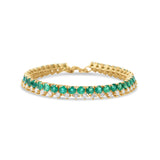 Timeless 14K yellow gold line bracelet featuring vibrant emeralds and radiant diamonds, offering a bold yet sophisticated design with an adjustable fit for versatile wear.