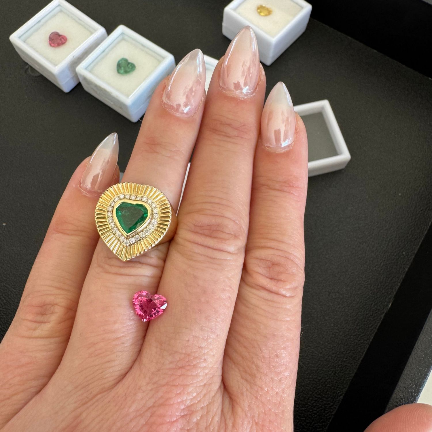 Handcrafted in 14K yellow gold, the softly fluted band creates a dimensional backdrop for a 1.18ct faceted emerald heart, prized for its vivid green hue. A halo of 25 pavé-set diamonds (0.22ct, F–G VS) encircles the center stone, adding a brilliant frame that enhances its natural beauty. Designed with a low-profile setting for effortless wear, the ring combines timeless romance with modern edge—perfect for marking life’s most meaningful moments or as a signature everyday piece.