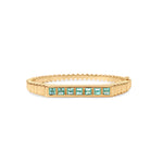 Timeless 14K yellow gold fluted bangle featuring vibrant bezel-set baguette emeralds, offering a refined design that adds a touch of elegance and color to any ensemble. Front View