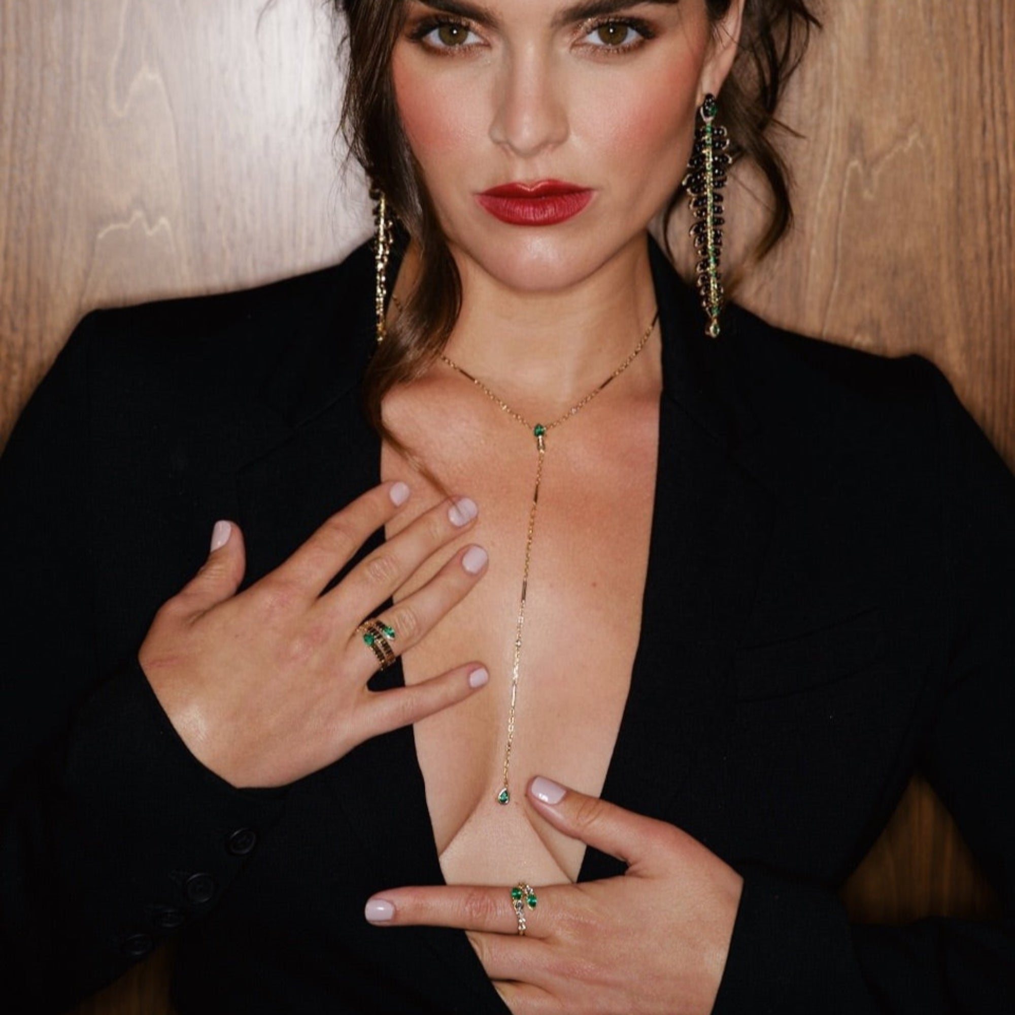 Elegant 14K yellow gold fluted wrap ring featuring two pear-shaped emeralds, blending textured gold craftsmanship with timeless sophistication for a modern yet classic statement piece. On models right hand. 