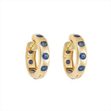 Striking 14K yellow gold huggie earrings featuring 1.79ct of vibrant blue sapphires, set in 1/2-inch wide hoops for a colorful and elegant everyday accessory.