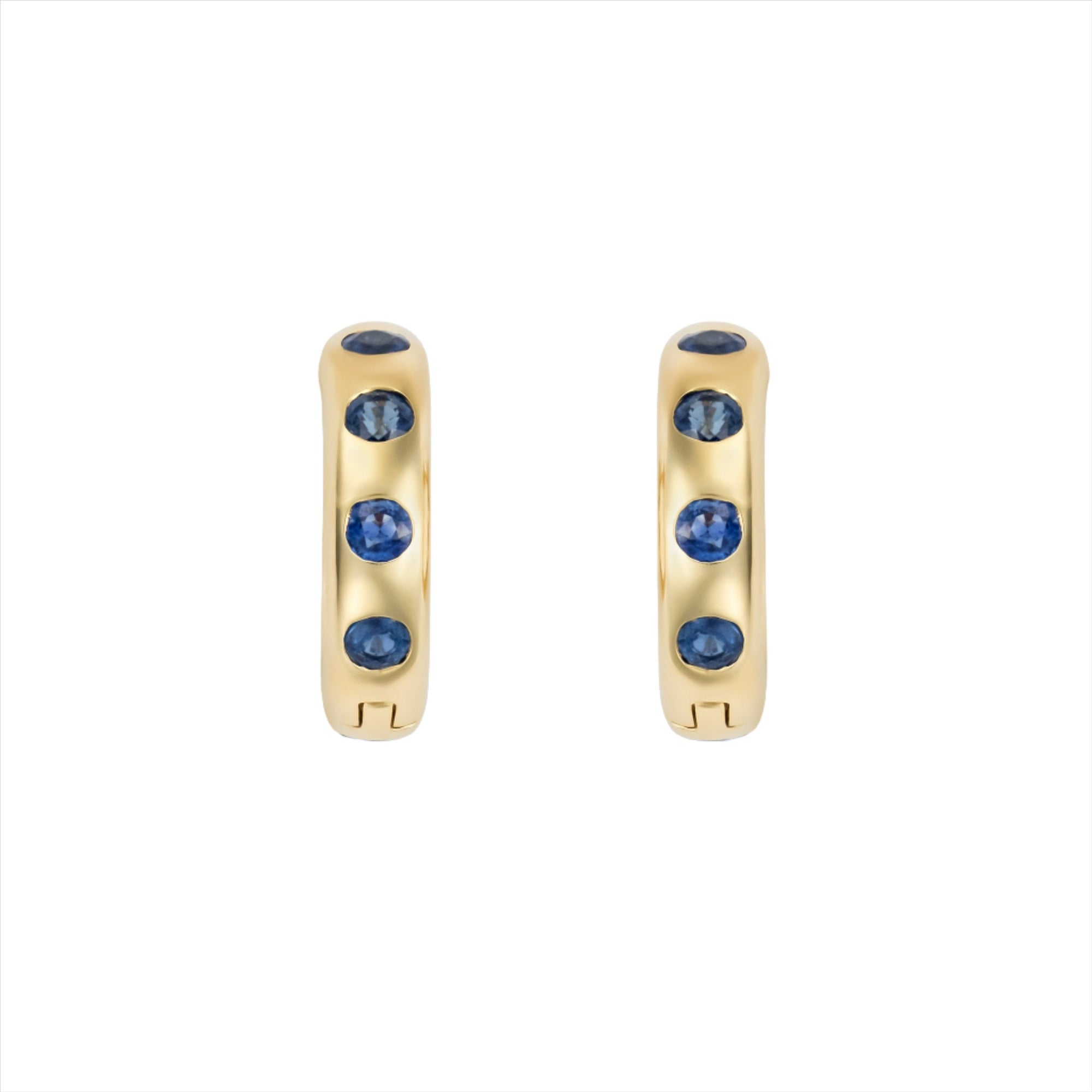 Striking 14K yellow gold huggie earrings featuring 1.79ct of vibrant blue sapphires, set in 1/2-inch wide hoops for a colorful and elegant everyday accessory.