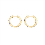 Striking 14K yellow gold huggie earrings featuring 1.79ct of vibrant blue sapphires, set in 1/2-inch wide hoops for a colorful and elegant everyday accessory.