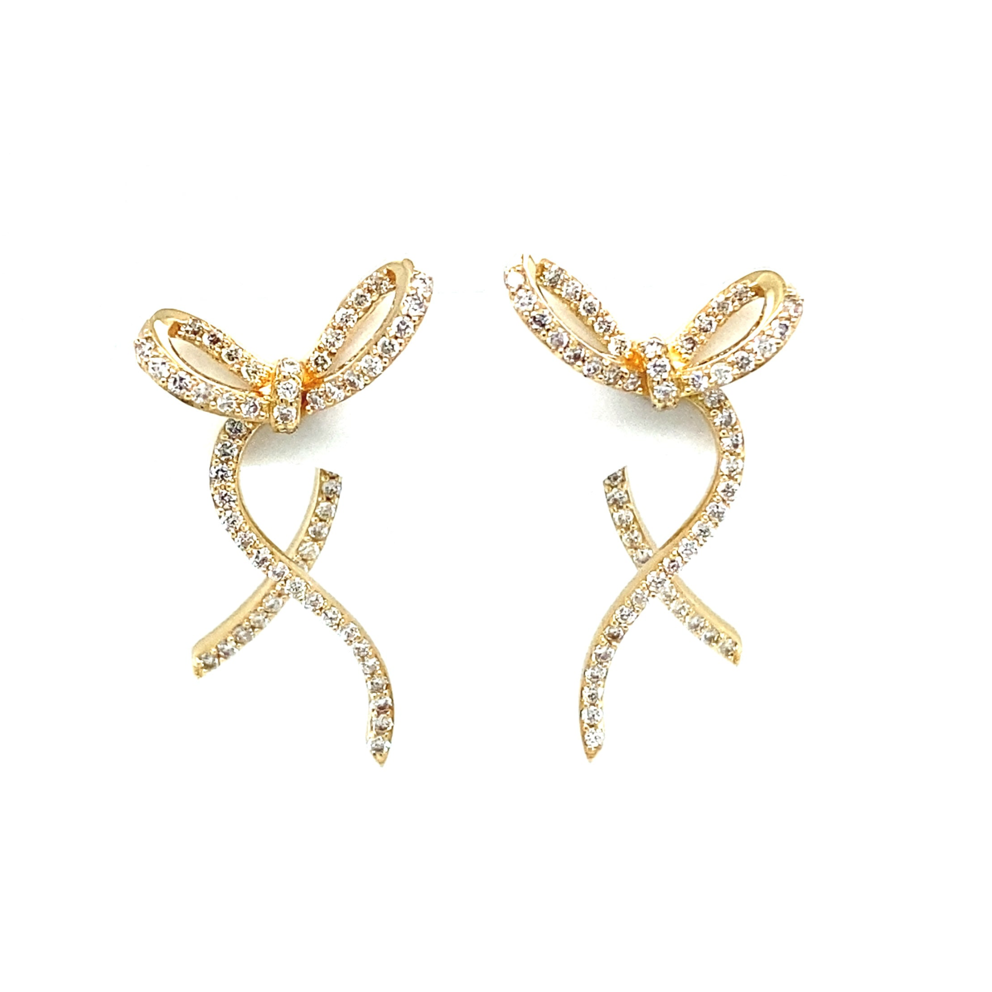 Charming 14K yellow gold bow stud earrings adorned with sparkling diamonds, offering a whimsical yet elegant touch to elevate any outfit. Close up.