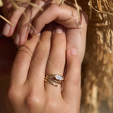 Elegant 14K yellow gold spiral ring featuring a sleek marquise-cut diamond, blending timeless luxury with modern minimalism, perfect for stacking or wearing alone. On model, right ring finger.