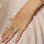 Beautiful 14K yellow gold knot ring featuring a vibrant spray of Zambian emeralds totaling 0.98ct, offering a luxurious and modern twist on a timeless design.