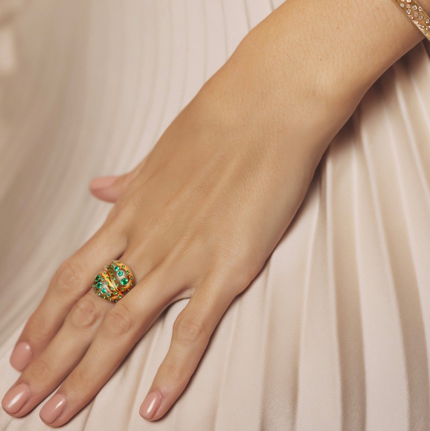 Beautiful 14K yellow gold knot ring featuring a vibrant spray of Zambian emeralds totaling 0.98ct, offering a luxurious and modern twist on a timeless design.